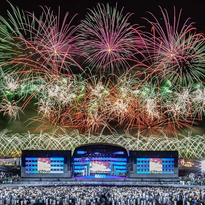 Multitud en un evento corporativo con fuegos artificiales